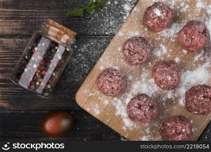 flat lay meatballs wooden board with pepper