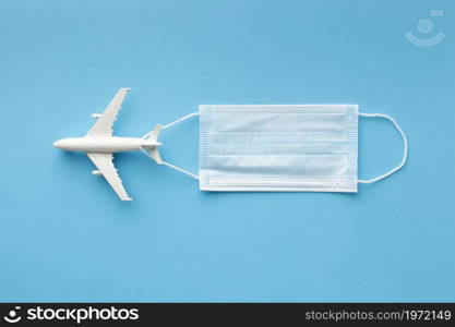 flat lay medical mask with airplane figurine. High resolution photo. flat lay medical mask with airplane figurine. High quality photo