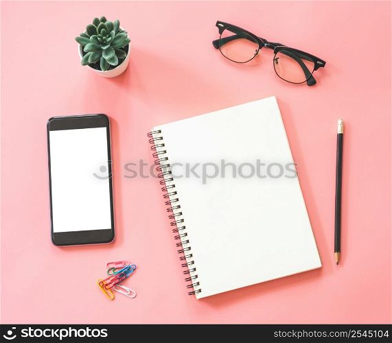 Flat lay mockup design of workspace desk with blank notebook, smartphone, stationery on pink pastel color with copy space