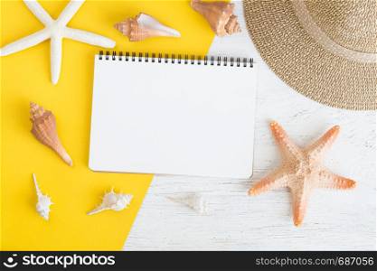 Flat lay notebook with blank and seashell for summer holiday on yellow paper on whitewood,Top view from above