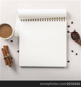 flat lay notebook with coffee cup cinnamon sticks