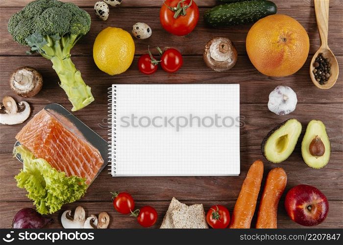 flat lay notebook with lots vegetables salmon