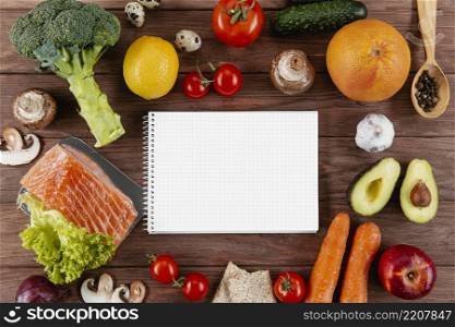 flat lay notebook with lots vegetables salmon