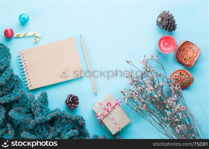 Flat lay of blank craft notebook, Christmas ornaments and gift boxes on pastel color background