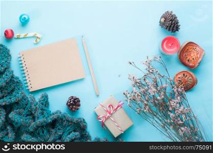 Flat lay of blank craft notebook, Christmas ornaments and gift boxes on pastel color background