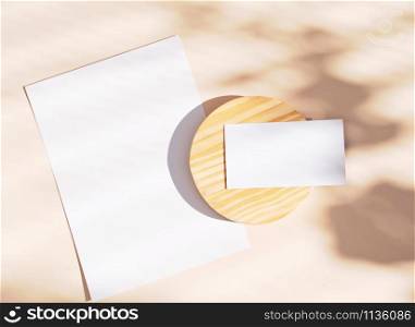 Flat lay of branding identity business name card and blank paper on yellow background, light and shadow shape leaves, minimal concept for design