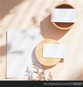 Flat lay of branding identity business name card on yellow background with flower and wooden container, light and shadow shape, minimal concept for design