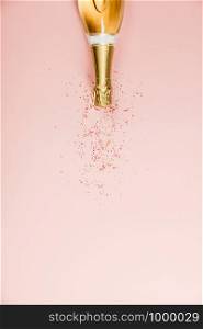 Flat lay of Celebration. Champagne bottle with sprinkles. Flat lay of Celebration. Champagne bottle with sprinkles on pink background.