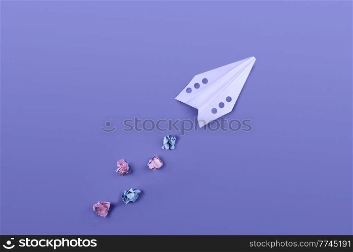 Flat lay of color paper plane colored in trendy violet color.. Paper plane colored in trendy violet color