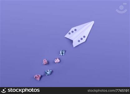 Flat lay of color paper plane colored in trendy violet color.. Paper plane colored in trendy violet color