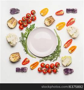 Flat lay of colorful salad vegetables ingredients around empty plate with seasoning on white background, top view. Healthy clean eating layout, vegetarian food and diet nutrition concept