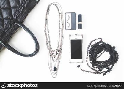 Flat lay of empty notebook, cellphone and woman's accessories in black concept, top view, isolated on white background