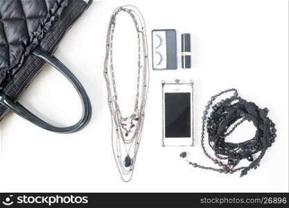 Flat lay of empty notebook, cellphone and woman's accessories in black concept, top view, isolated on white background