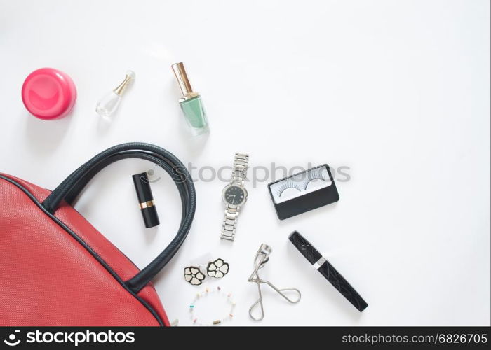 Flat lay of female items out of hand bag on white background