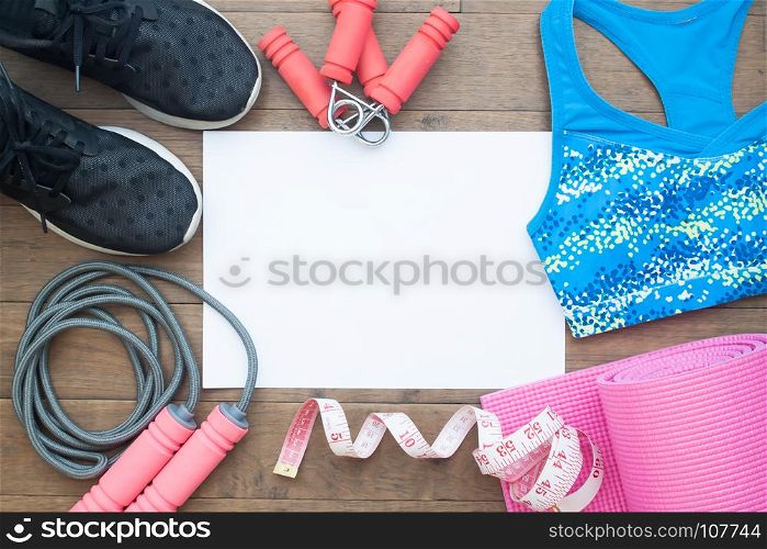 Flat lay of Fitness equipments. Healthy and Diet concept. Yoga mat, sneakers, sport bra, measuring-tape, water on wooden background with copy space