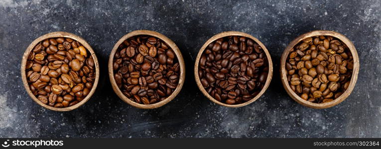 Flat lay of Four different varieties of coffee beans on dark marble background, copyspace. Four different varieties of coffee beans, flat lay, top view