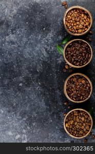 Flat lay of Four different varieties of coffee beans on dark marble background, copyspace. Four different varieties of coffee beans, flat lay, top view