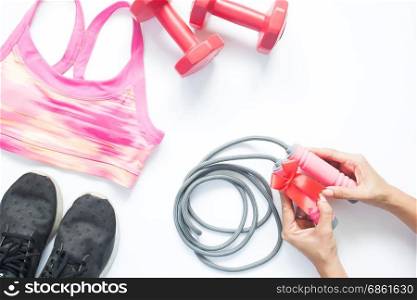 Flat lay of gym and workout equipments with woman hand holding gift, Healthy and fitness concept
