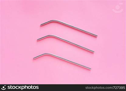 Flat lay of metallic stainless straws for drink on bright pink background, sustainable lifestyle and zero waste concept