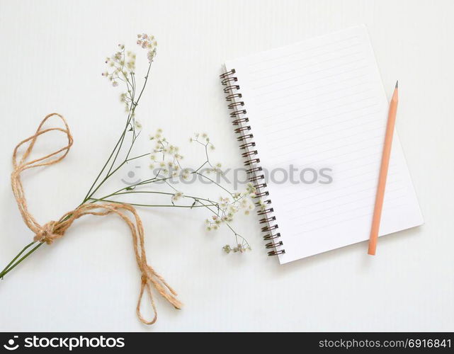 Flat lay of minimal workspace desk with notebook and flower, copy space