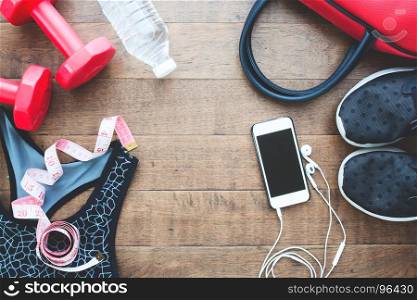 Flat lay of mobile phone and fitness equipments with measuring-tape on wood background, Sport and healthy concept
