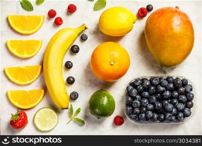 Flat-lay of organic fruits on white marble background. Healthy, clean eating, vegan, vegetarian, detox, dieting breakfast food concept. Flat-lay of organic fruits. Flat-lay of organic fruits