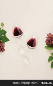 Flat-lay of red wine in glasses, Branch of grape vine and grape on pink background. Wine bar, winery, wine degustation concept. Minimalistic trendy photography