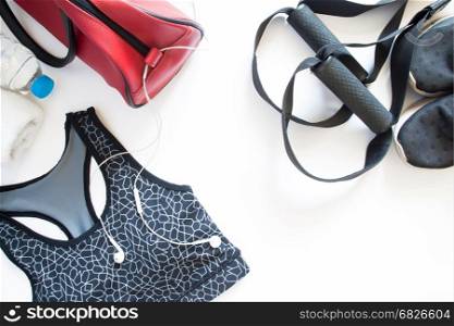 Flat lay of sport bra, sneaker, towel and bottle of water, sport equipments, fitness items, top view