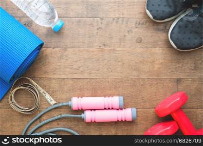 Flat lay of sport equipments on wood background with copy space