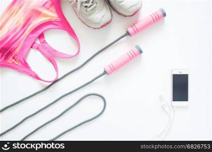 Flat lay of sport items in pink concept with mobile device, isolated on white background