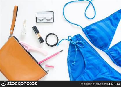 Flat lay of summer fashion with blue stripe bikini and girl accessories on white background
