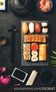 Flat-lay of sushi set on dark rustic background, flat lay. Flat-lay of sushi set on dark rustic background