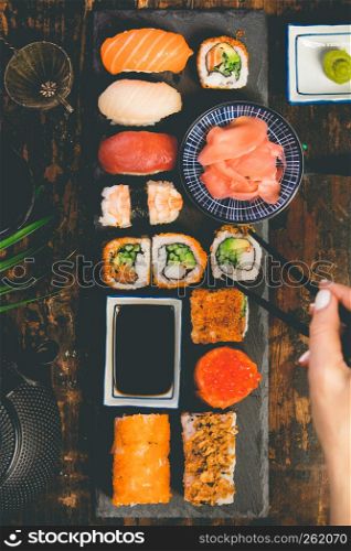 Flat-lay of sushi set on grey concrete background. Flat-lay of sushi set on dark background, vertical composition