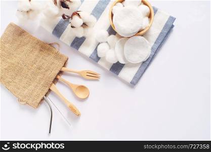 Flat lay of sustainable products, wooden spoon, stainless straw and natural cotton on white background and copy space, eco friendly and zero waste concept