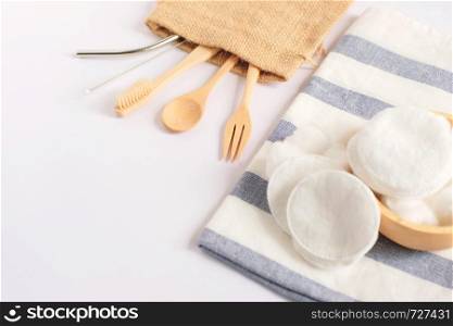 Flat lay of sustainable products, wooden spoon, stainless straw and natural cotton on white background and copy space, eco friendly and zero waste concept