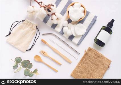 Flat lay of sustainable products, wooden spoon, stainless straw, organic cosmetic and natural cotton on white background, eco friendly and zero waste concept