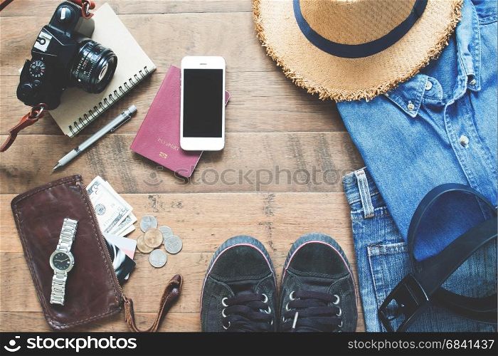 Flat lay of Treveler's items, Essential vacation accessories of young smart traveler, Travel concept on wood background