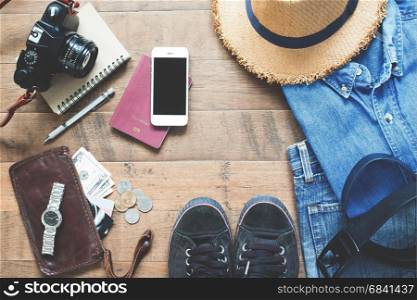 Flat lay of Treveler's items, Essential vacation accessories of young smart traveler, Travel concept on wood background