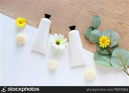 Flat lay of various organic skincare and beauty products for mock up with green leaves in minimal style