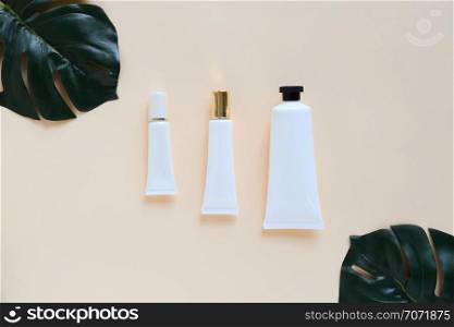 Flat lay of various organic skincare and beauty products for mock up with green leaves in minimal style