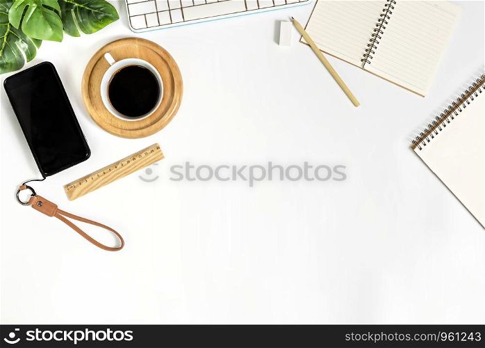 Flat lay of white office desk table with blank notebook, supplies and coffee cup. Top view with copy space.. blank sketchbook and green leaves