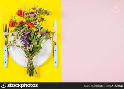 Flat lay of wild flower bouquet on white plate. Clean eating, paleo, biohacking, herbal medicine concept. Healthy eating and herbal medicine concept, flat lay, top view