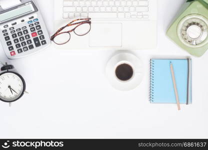 Flat lay of workspace desk with white laptop, stationery and cup of coffee