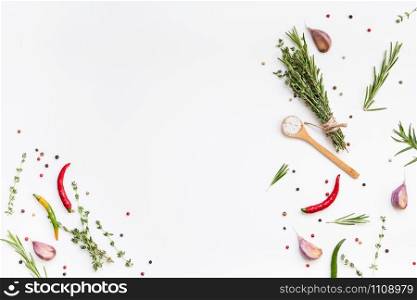 Flat lay overhead top view of greens herbs and spices on white background with copy space. Menu frame design food pattern background with cooking ingredients