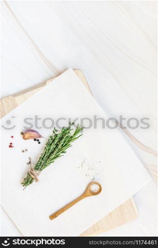 Flat lay overhead top view of greens herbs and spices on white marble background with copy space. Menu frame design food pattern background with cooking ingredients