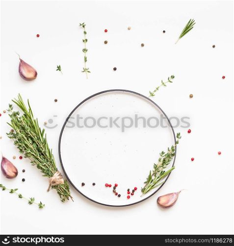 Flat lay overhead view empty plate mockup blank text space invitation card on white background with greens herbs and spices. Menu design food background with cooking ingredients