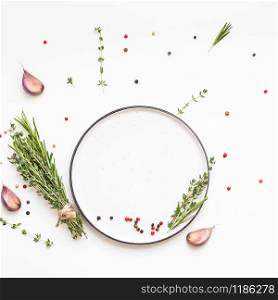 Flat lay overhead view empty plate mockup blank text space invitation card on white background with greens herbs and spices. Menu design food background with cooking ingredients