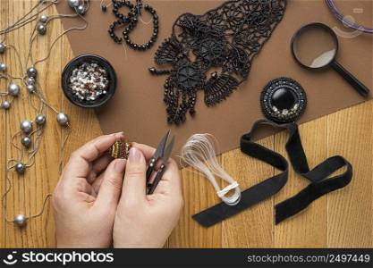 flat lay person doing bead work with scissors