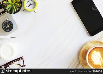 Flat lay photo in top view of business accessories, mobile, alarm clock, laptop, coffee, glasses and compass on white marble table with free copy space for text. Business and technology concept.