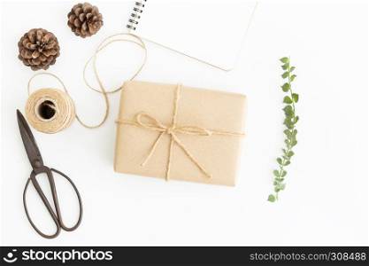 Flat lay photo of gift wrap and old scissors on white background,Handcrafted accessories and brown gift box